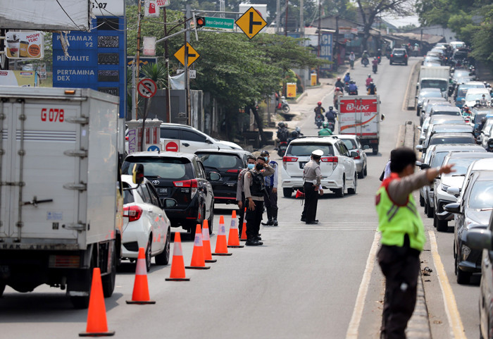 Petugas melakukan penyekatan kendaraan di Kawasan Jalan Raya Parung-Ciputat, Bojong Sari, Depok, Jawa Barat, Minggu (16/5/2021).