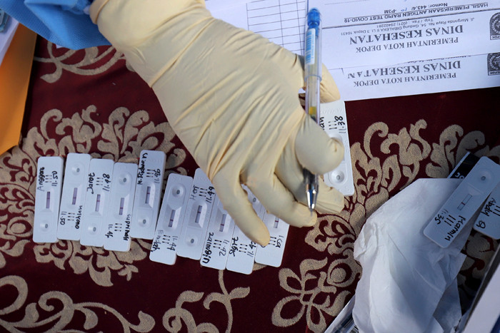 Petugas kesehatan mengambil sampel lendir pengendara saat tes swab antigen di Penyekatan Bojongsari, Depok, Jawa Barat, Minggu (16/5/2021).