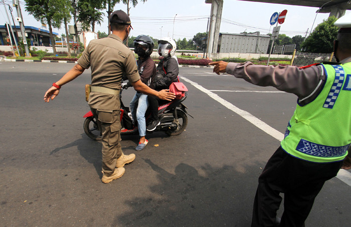 Petugas memberitahu TMII tutup kepada pengendara di TMII, Jakarta Timur, Minggu (16/5/2021).