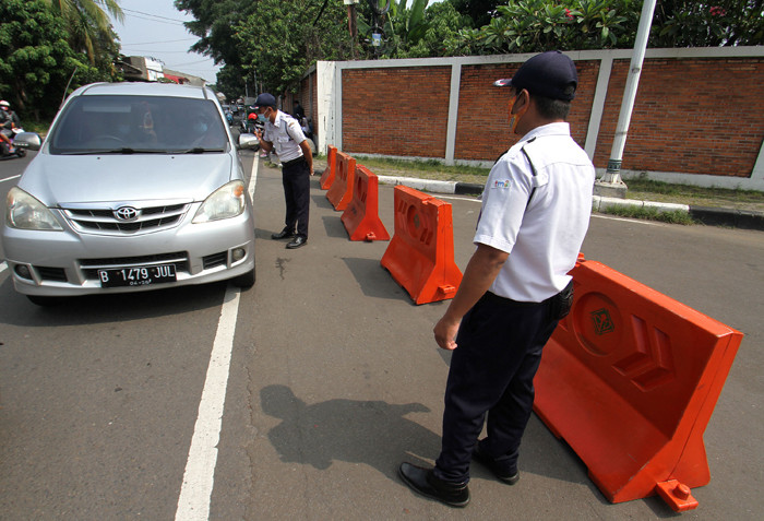 Petugas memberitahu TMII tutup kepada pengendara di TMII, Jakarta Timur, Minggu (16/5/2021).