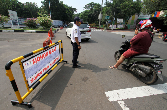 Petugas memberitahu TMII tutup kepada pengendara di TMII, Jakarta Timur, Minggu (16/5/2021).