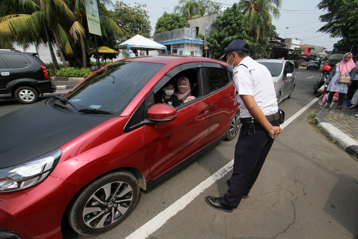 Petugas memberitahu TMII tutup kepada pengendara di TMII, Jakarta Timur, Minggu (16/5/2021).