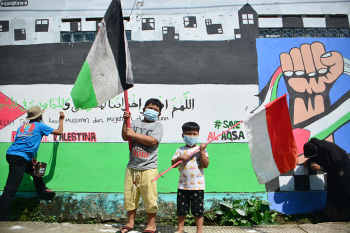 Remaja menyelesaikan pembuatan mural bertema solidaritas Palestina di Gang Jambu, Kedaung, Depok, Jawa Barat, Selasa (18/5/2021).