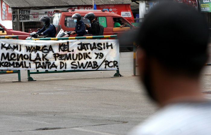 Pengendara melintasi spanduk bertuliskan himbauan kepada warga pemudik wajib test Covid-19 di kawasan Jatiasih, Kota Bekasi, Jawa Barat, Selasa (18/5/2021).