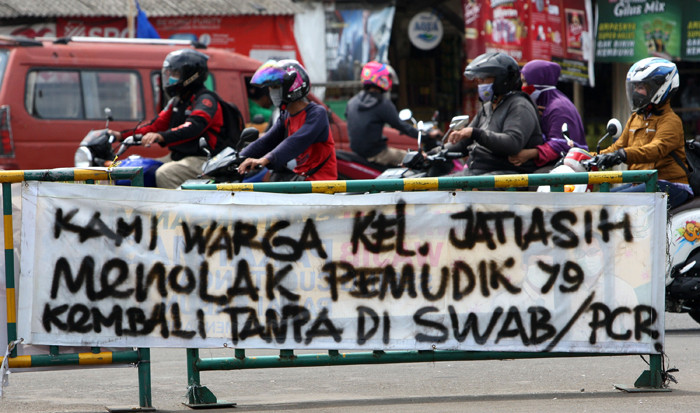 Pengendara melintasi spanduk bertuliskan himbauan kepada warga pemudik wajib test Covid-19 di kawasan Jatiasih, Kota Bekasi, Jawa Barat, Selasa (18/5/2021).