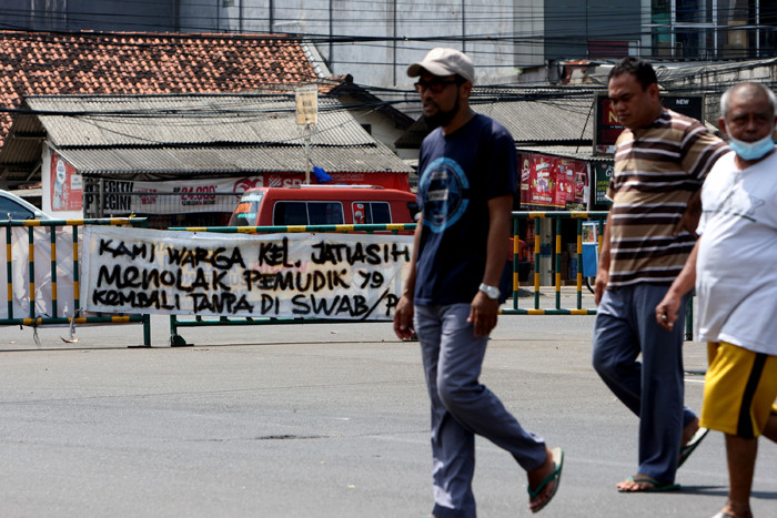 Pengendara melintasi spanduk bertuliskan himbauan kepada warga pemudik wajib test Covid-19 di kawasan Jatiasih, Kota Bekasi, Jawa Barat, Selasa (18/5/2021).