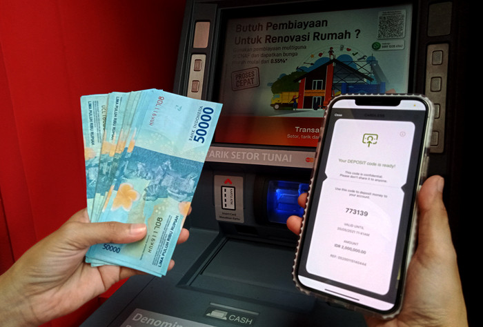 Nasabah melakukan setoran tunai tanpa kartu menggunakan OCTO Mobile di mesin Tarik Setor Tunai di Digital Lounge at Home CIMB Niaga, Jakarta, Kamis (20/5/2021).