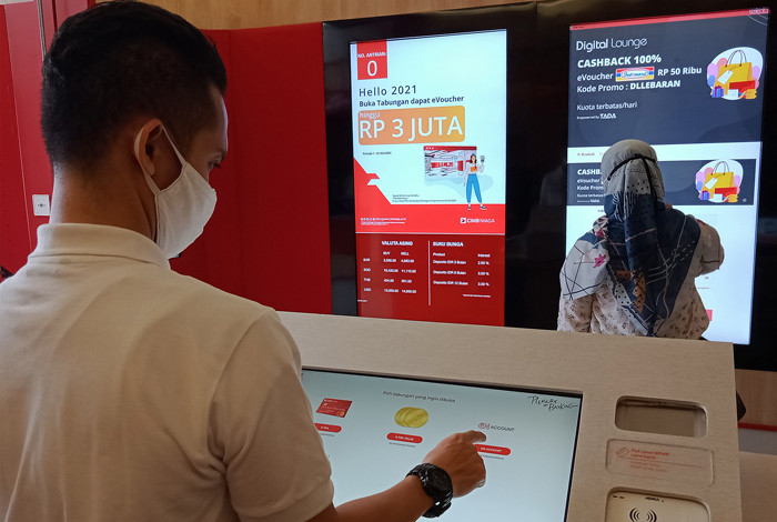 Nasabah melakukan setoran tunai tanpa kartu menggunakan OCTO Mobile di mesin Tarik Setor Tunai di Digital Lounge at Home CIMB Niaga, Jakarta, Kamis (20/5/2021).