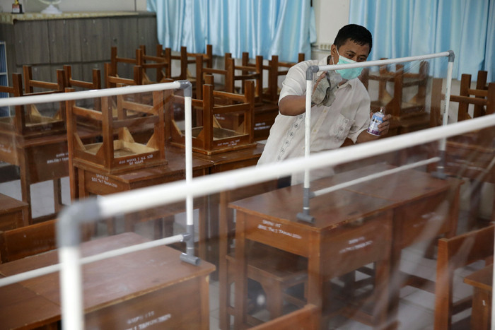 Petugas menyiapkan ruangan kelas yang akan digunakan untuk seleksi Penerimaan Peserta Didik Baru (PPDB) di SMPN 115 Jakarta, Jumat (21/5/2021).