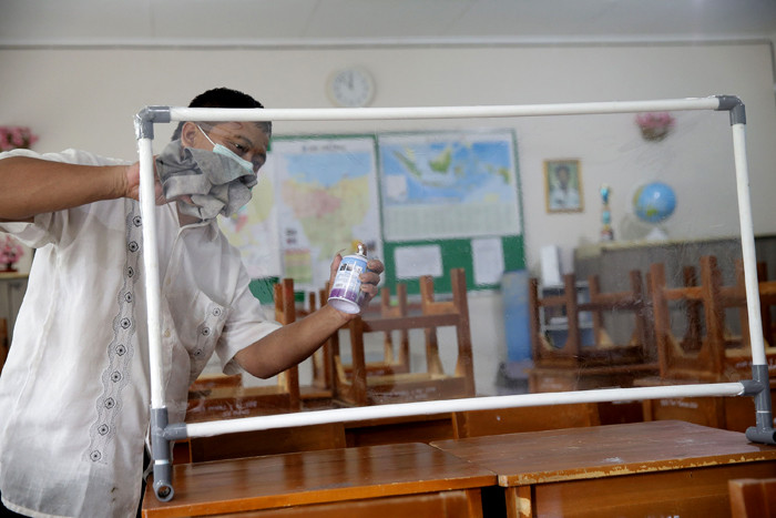 Petugas menyiapkan ruangan kelas yang akan digunakan untuk seleksi Penerimaan Peserta Didik Baru (PPDB) di SMPN 115 Jakarta, Jumat (21/5/2021).