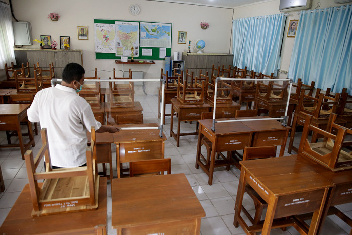 Petugas menyiapkan ruangan kelas yang akan digunakan untuk seleksi Penerimaan Peserta Didik Baru (PPDB) di SMPN 115 Jakarta, Jumat (21/5/2021).