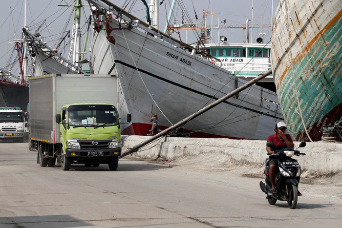 Pengendara melintasi kapal yang bersandar di Pelabuhan Sunda Kelapa, Jakart Utara, Jumat (21/5/2021).