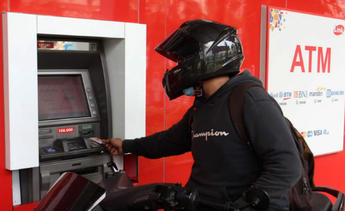 Seorang nasabah sedang melakukan transaksi di ATM Link di Jakarta, Minggu (23/5/2021).