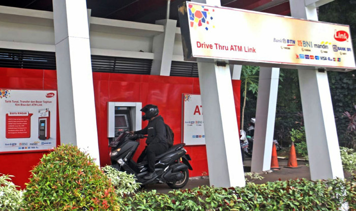 Seorang nasabah sedang melakukan transaksi di ATM Link di Jakarta, Minggu (23/5/2021).
