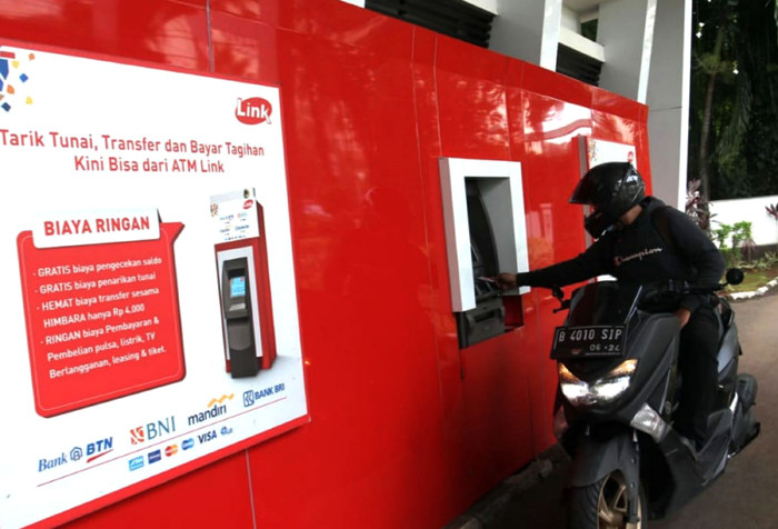 Seorang nasabah sedang melakukan transaksi di ATM Link di Jakarta, Minggu (23/5/2021).