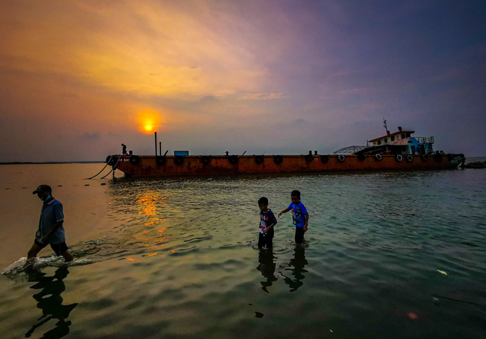 Suasana aktivitas warga sore menjelang malam di kawasan pelabuhan kaliadem, Jakarta Utara, Minggu (23/5/2021).