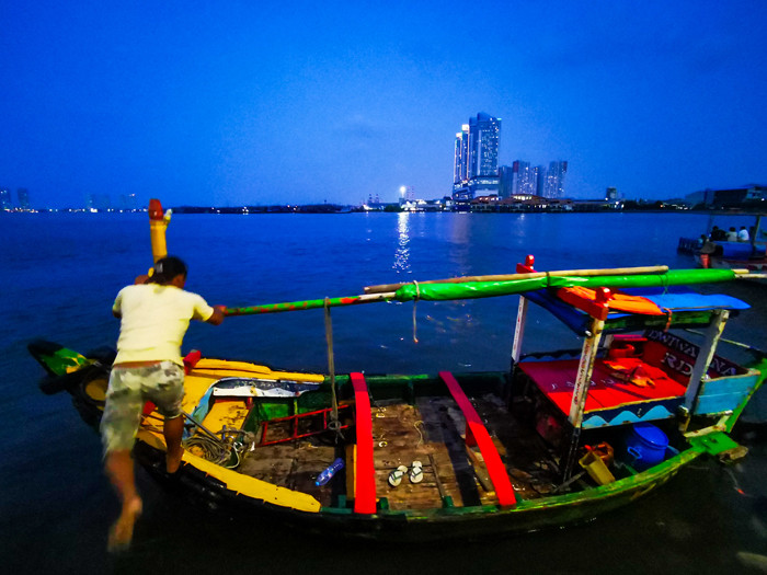 Suasana aktivitas warga sore menjelang malam di kawasan pelabuhan kaliadem, Jakarta Utara, Minggu (23/5/2021).