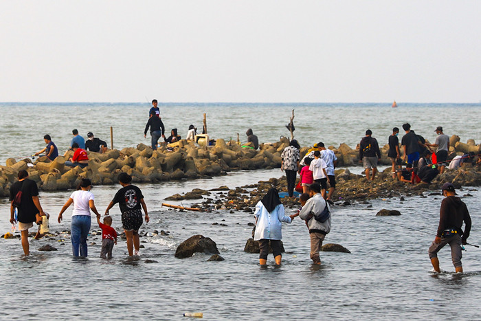 Warga menikmati liburan akhir pekan di Dermaga Muara Angke, Jakarta Utara, Minggu (23/5/2021).