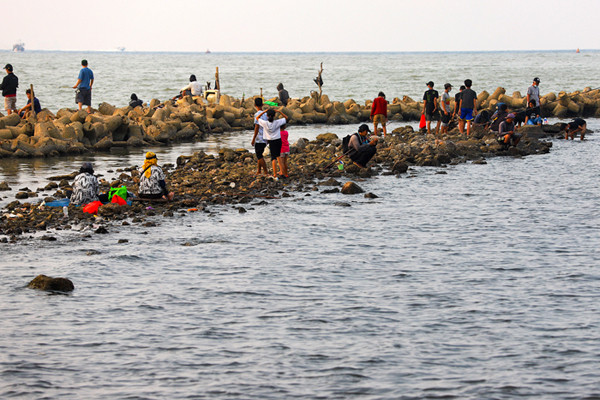 Warga menikmati liburan akhir pekan di Dermaga Muara Angke, Jakarta Utara, Minggu (23/5/2021).