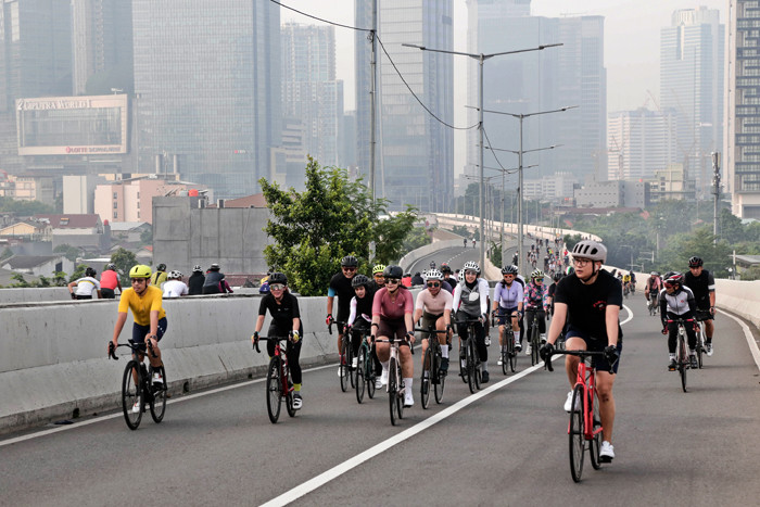 Pesepeda melintasi Jalan Layang Non-Tol (JLNT) Kampung Melayu-Tanah Abang, Jakarta, Minggu (23/5/2021).