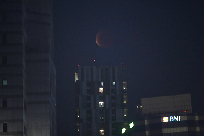 Warga memotret fenomena Gerhana Bulan Total atau Super Blood Moon di kawasan Pancoran, Jakarta, Rabu (26/5/2021).