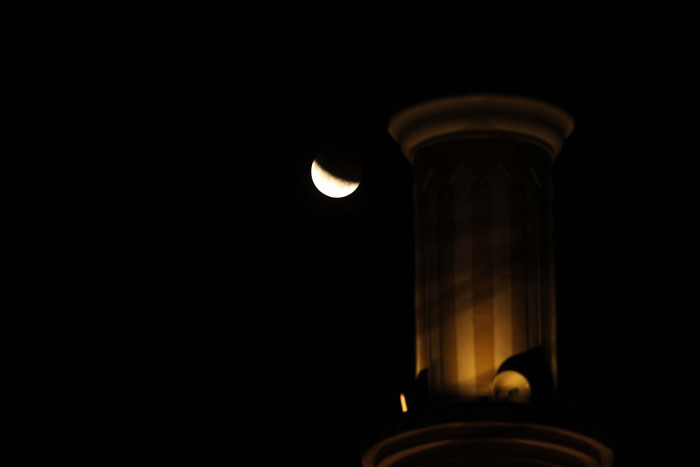 Fase gerhana bulan total terlihat dengan latar depan menara Masjid An-Nur Gandul, Depok, Jawa Barat. Rabu (26/5/2021).
