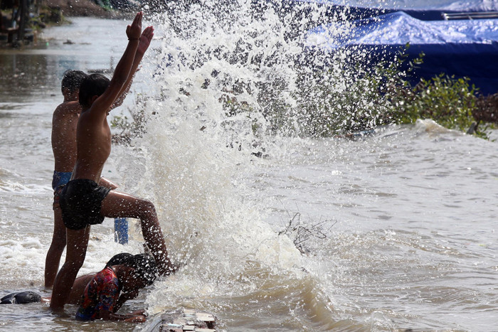 Sejumlah anak bermain dibibir pantai ketika banjir rob menerjang kawasan wisata Kenjeran Park Surabaya, Jawa Timur, Jumat (28/5/2021).
