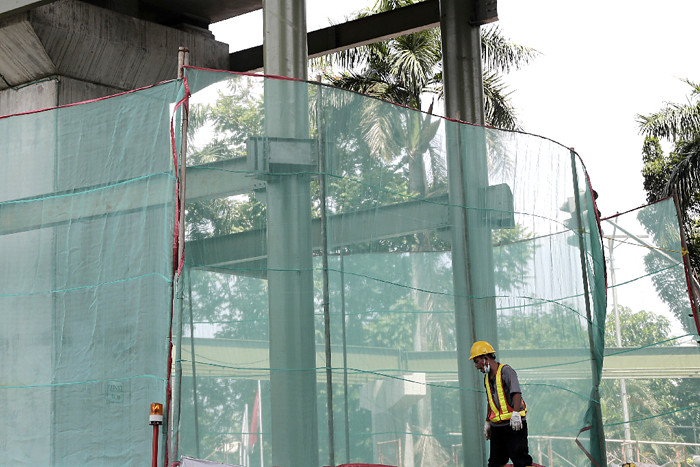 Pekerja menyelesaikan pembangunan proyek jembatan layang atau skybridge untuk integrasi Halte Transjakarta CSW di stasiun MRT ASEAN, Jakarta, Jumat (28/5/2021).