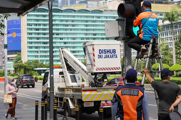 Petugas memperbaiki lampu lalu lintas di penyebrangan orang di Bundaran HI, Jakarta Pusat, Minggu (30/5/2021).