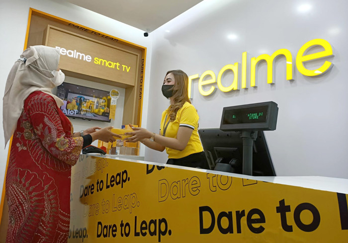 Karyawati melayani pelanggan di gerai terbaru Realme di Surabaya, Jawa Timur, Minggu (30/5/2021).