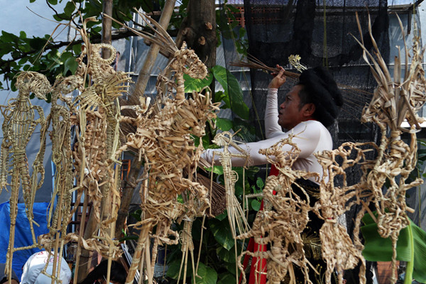 Seniman Meimura memerankan Besut Rusmini ketika memainkan wayang suket di Sanggar Anak Merdeka Indonesia, Surabaya, Jawa Timur, Senin (31/5/2021).