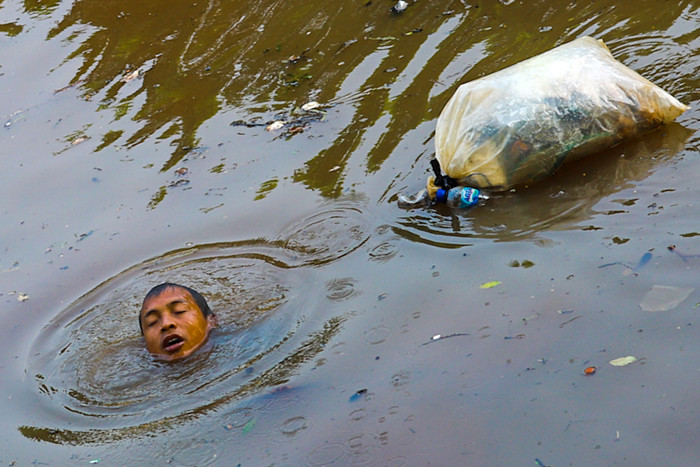 Warga mencari cacing sutra untuk pakan ikan cupang di Banjir Kanal Barat, Jakarta Barat, Selasa (1/6/2021).