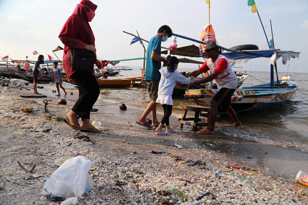 Pengunjung bermain di Pantai Kenjeran Surabaya, Jawa Timur, Selasa (1/6/2021).