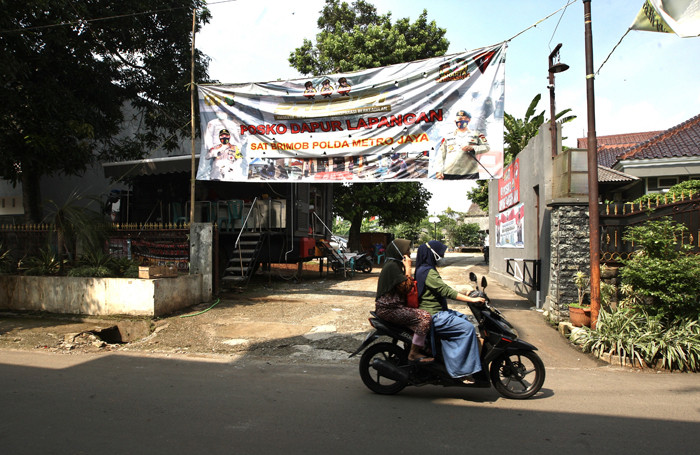 Warga melintas di Jalan Darusalam di kawasan RT 03 RW 03 Cilangkap, Cipayung, Jakarta Timur, Kamis (3/6/2021).
