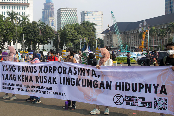 Aktivis melakukan aksi dalam rangka Hari Lingkungan Hidup Sedunia di Jalan Medan Merdeka Selatan, Jakarta, Jumat (4/6/2021).