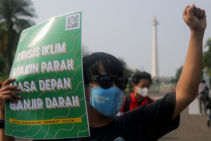Aktivis melakukan aksi dalam rangka Hari Lingkungan Hidup Sedunia di Jalan Medan Merdeka Selatan, Jakarta, Jumat (4/6/2021).
