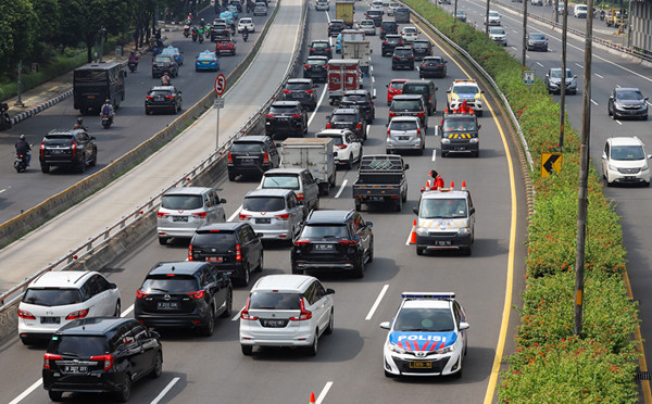 Petugas kembali membuka jalur yang dipakai untuk sistem contraflow di Jalan Jenderal Gatot Subroto, Jakarta, Jumat (4/6/2021).