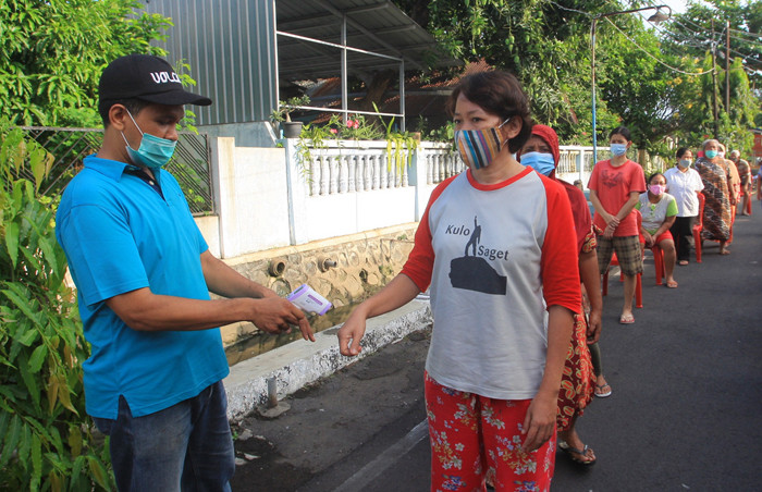 Warga mengantre untuk mendapatkan sayuran yang dibagikan di wilayah RW 5 Kelurahan Pendrikan Lor, Kecamatan Semarang Tengah, Kota Semarang, Minggu (6/6/2021).