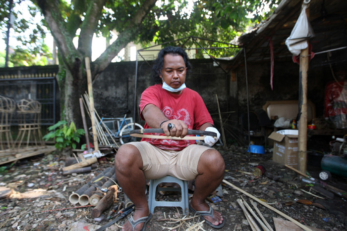 Wawan menyiapkan bambu untuk dijadikan bahan pembuatan kerangka ondel-ondel di kawasan Perkampungan Budaya Betawi Setu Babakan, Jagakarsa, Minggu (6/6/2021).