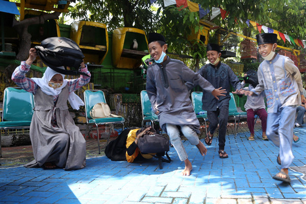 Peserta bersembunyi dibawah meja ketika mengikuti simulasi bencana alam di Koramil Tipe A 0831/04 Sukolilo Surabaya, Jawa Timur, Minggu (6/6/2021).