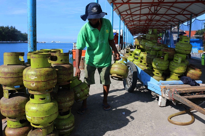 Pekerja harian lepas menurunkan gas elpji 3 kg di Pelabuhan Dermaga Pulau Panggang Provinsi DKI Jakarta, Senin (7/6/2021).