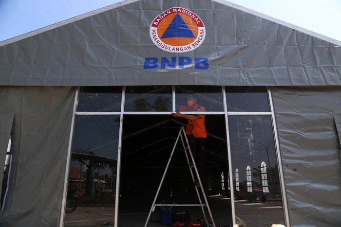 Relawan BNPB mendirikan tenda darurat di halaman kantor Badan Pengembangan Wilayah Suramadu (BPWS) Bangkalan, Madura, Jawa Timur, Selasa (8/6/2021).
