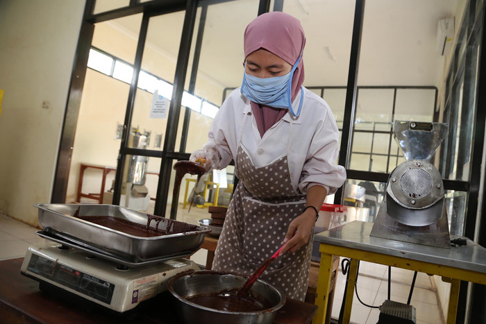 Pekerja menyelesaikan proses produksi coklat di Pabrik Coklat di area wisata Doesoen Kakao, Kendenglembu, Desa Karangharjo, Banyuwangi, Rabu (9/6/2021).