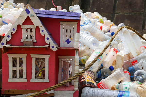 Petugas mengangkut sampah botol plastik dari kali Ciliwung, Jakarta Pusat, Kamis (10/6/2021).