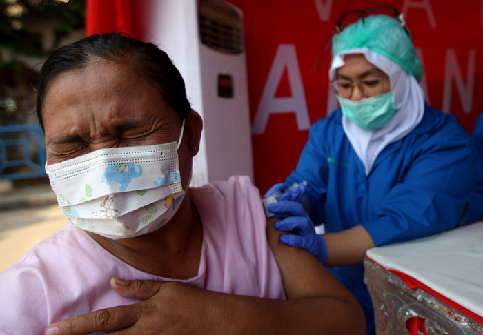 Pedagang, supir bus dan kernet saat terima vaksin AstraZeneca tahap pertama di Terminal Kampung Rambutan, Jakarta, Kamis (10/6/2021).