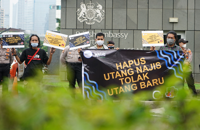 Aktivis Walhi menunjukkan poster saat menggelar aksi unjuk rasa di depan Kedubes Inggris, Kuningan, Jakarta, Jumat (11/6/2021).