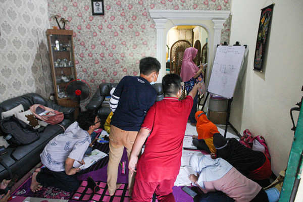 Seorang anak sedang belajar mengerjakan soal dari sekolah dibantu pengajar bimbingan belajar (bimbel) di kawasan Condet, Jakarta Timur, Jumat (11/6/2021).