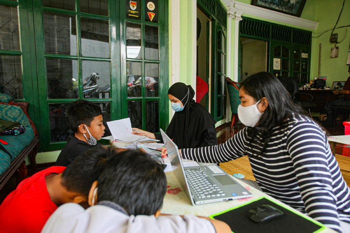 Seorang anak sedang belajar mengerjakan soal dari sekolah dibantu pengajar bimbingan belajar (bimbel) di kawasan Condet, Jakarta Timur, Jumat (11/6/2021).