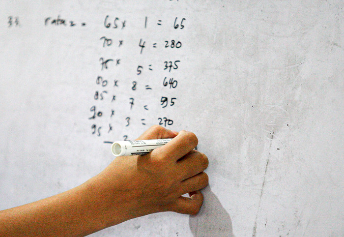 Seorang anak sedang belajar mengerjakan soal dari sekolah dibantu pengajar bimbingan belajar (bimbel) di kawasan Condet, Jakarta Timur, Jumat (11/6/2021).