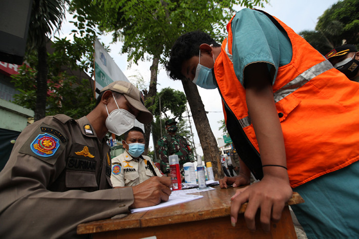 Warga terjaring razia masker yang diadakan petugas Satpol PP di kawasan Tanjung Duren, Jakarta, Jumat (11/6/2021).